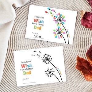 May include: Two white Father's Day cards with dandelion designs. One card features colorful fingerprint flowers, the other a black and white illustration. Text reads "I couldn't Wish For a better Dad" and "I love you!"