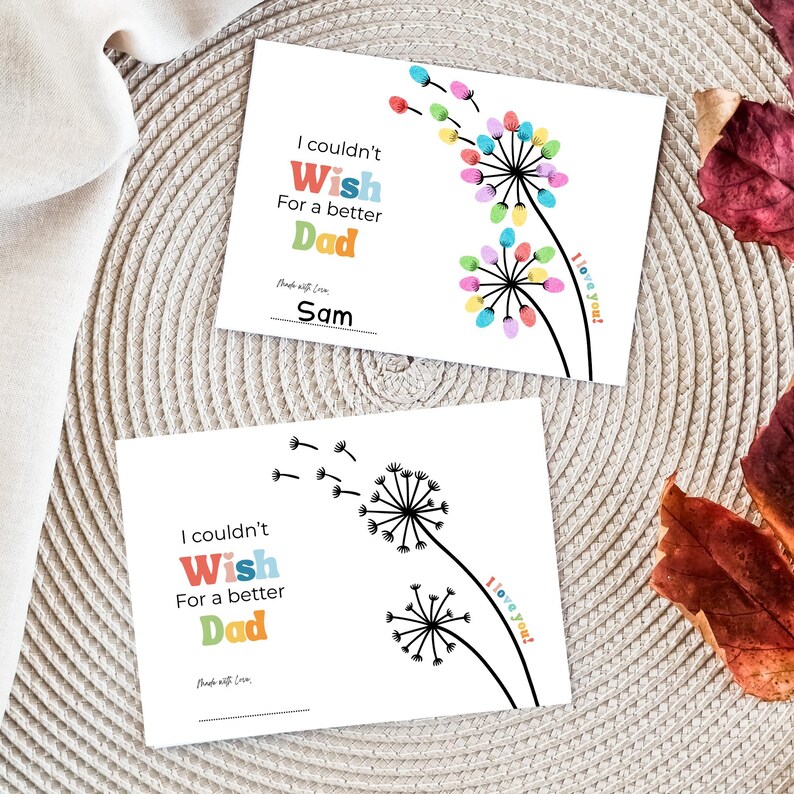 May include: Two white Father's Day cards with dandelion designs. One card features colorful fingerprint flowers, the other a black and white illustration. Text reads "I couldn't Wish For a better Dad" and "I love you!"