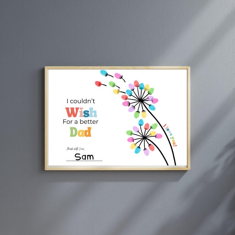 May include: A framed print with a white background features colorful dandelion-like designs made of fingerprints. Text reads "I couldn't Wish for a better Dad" with the name "Sam" below. The phrase "I love you!" is also included.
