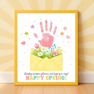 May include: A framed print with a yellow border features a pink handprint above a yellow envelope overflowing with flowers. The text "Sending sunshine, flowers, and hugs your way! HAPPY SPRING!" is at the bottom, with colorful accents.