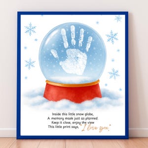May include: A framed print featuring a snow globe design with a handprint inside. The snow globe sits on a red base, surrounded by snowflakes. The text reads, "Inside this little snow globe, A memory made just as planned. This little print says, 'I love you.'"