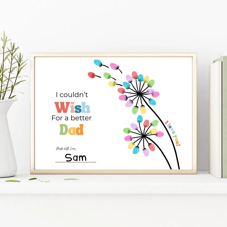 May include: A framed print with the text "I couldn't Wish For a better Dad". The artwork features colorful finger-painted flowers and the words "I love you!" and "Made with Love, Sam".