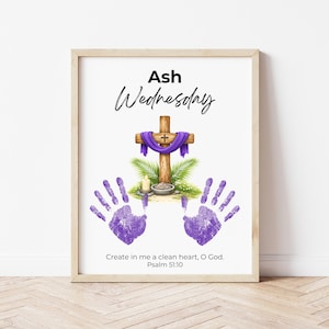 Puede incluir: Impresión enmarcada con las palabras "Ash Wednesday" en escritura negra. Una cruz de madera con una tela morada está centrada sobre un cuenco pequeño, hojas de palma y una vela. Dos huellas de manos moradas están debajo, con el texto "Crea en mí un corazón limpio, oh Dios. Salmo 51:10."
