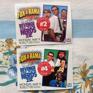 May include: Two Fox-O-Rama "Revenge of the Nerds IV" promotional cards. Each card features a cast photo, the show's title, and the Fox logo. One card has a "Scratch Here #2" sticker, the other has a "Scratch Here #4" sticker.