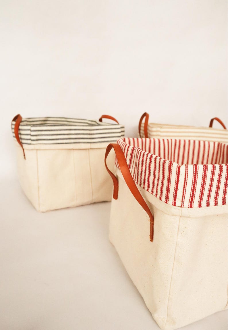 May include: A set of three ceramic mugs with a speckled, matte finish. The mugs are in shades of cream, light gray, and dark gray. Each mug has a simple, minimalist design, perfect for coffee or tea.