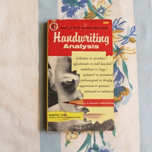 May include: A vintage red and yellow book titled "Handwriting Analysis" with the subtitle "How to discover the truth about people". The book cover features a black and white photo of a person's face and a yellow pencil.