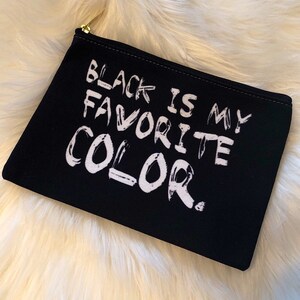 Könnte beinhalten: Schwarze Canvas-Kosmetiktasche mit dem Aufdruck "Black is my favorite color." in weiß.