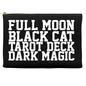 K&ouml;nnte beinhalten: Schwarze Rei&szlig;verschlusstasche mit wei&szlig;em Text, der "Full Moon Black Cat Tarot Deck Dark Magic" lautet.