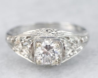 May include: A vintage engagement ring with a round brilliant cut diamond set in a filigree platinum band.