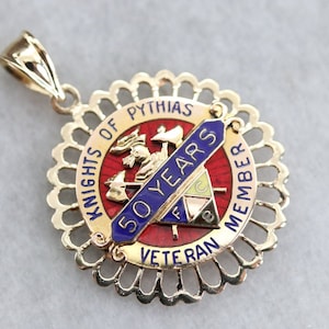 May include: Gold-toned pendant with a red, blue, and yellow enamel design. The pendant features the text "Knights of Pythias", "50 Years", "Veteran Member", and a knight's emblem.
