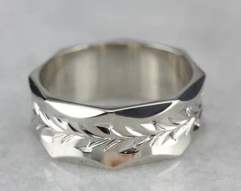 Puede incluir: Un anillo de plata con una banda texturizada y facetada y un diseño de hojas talladas.