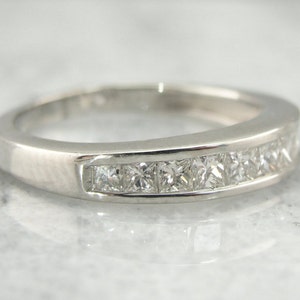 May include: A silver band ring with a row of small square-shaped diamonds set in a channel setting.