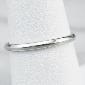 May include: A close-up of a silver wedding band with a smooth, polished finish.