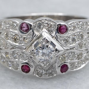 Anillo ancho de oro blanco con diamantes y detalles de rubí engastados en bisel.