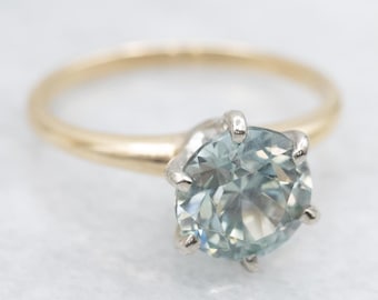 May include: A gold band ring with a prong setting featuring a light blue gemstone.