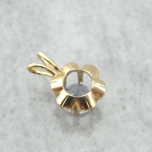 Op de afbeelding: Gouden hanger met een bloemvormige zetting voor een edelsteen. De zetting is leeg en klaar om met een steen te worden gevuld.