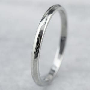 May include: A simple silver wedding band with a slightly rounded edge.