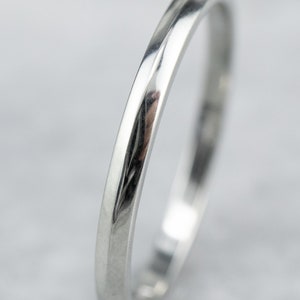 May include: A simple, polished silver wedding band with a slightly rounded edge.