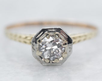May include: A vintage engagement ring with a round brilliant cut diamond set in a platinum octagonal setting. The band is yellow gold and has a delicate braided design.