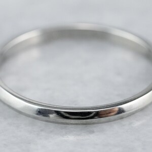 May include: A simple, polished silver wedding band.