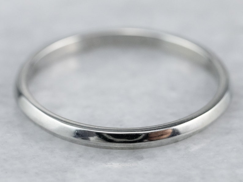 May include: A simple, polished silver wedding band.