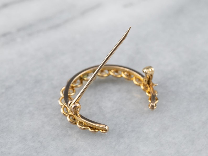 Puede incluir: Un broche de media luna de oro con un dise&ntilde;o de eslab&oacute;n de cadena. El broche tiene un cierre de pin y cierre.