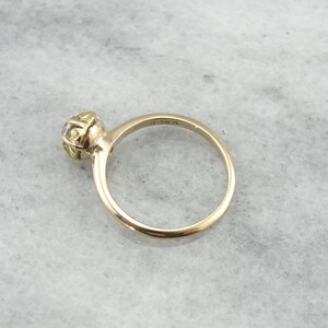 Puede incluir: Un anillo de oro con un solo diamante redondo engastado en un engaste de bisel. El anillo est&aacute; marcado con "15K" en el interior de la banda.