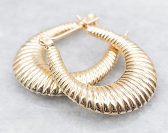 May include: A pair of gold hoop earrings with a textured, ribbed design. The earrings are made of a shiny metal and have a simple, classic style.