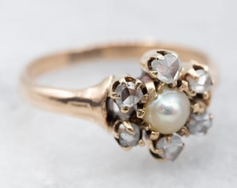 Könnte beinhalten: Ein goldener Ring mit einer Perle und Rosen-Schliff-Diamanten, die in einem Blumenmuster gesetzt sind.