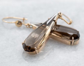 May include: A pair of gold earrings with teardrop-shaped smoky quartz stones.