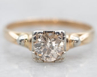 May include: A vintage engagement ring with a round, clear diamond set in a square, white gold setting. The band is yellow gold and has a twisted design.