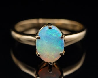 Anillo solitario de ópalo de seis puntas en oro amarillo