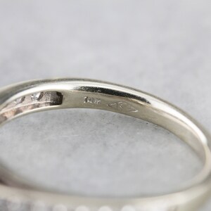 Puede incluir: Primer plano del interior de una banda de anillo, que muestra un sello de 14K y un peque&ntilde;o diamante engastado en la banda.