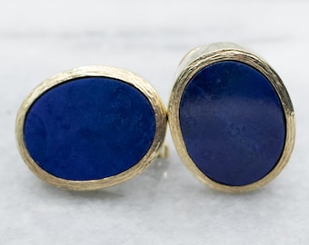 Könnte beinhalten: Ein Paar goldene ovale Ohrringe mit blauen Lapislazuli-Steinen.