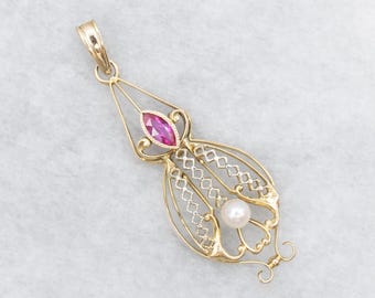 May include: A gold pendant with a marquise-cut pink gemstone and a round pearl. The pendant has an open filigree design with a decorative bail. The pendant is likely made of gold.