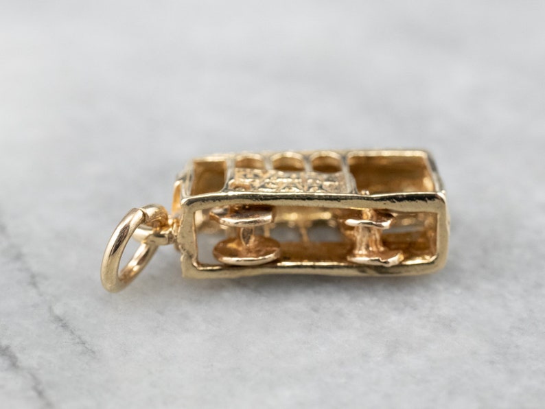 May include: Gold charm in the shape of a vintage train engine. The charm is detailed with wheels and windows. The charm has a loop for attaching to a necklace or bracelet.