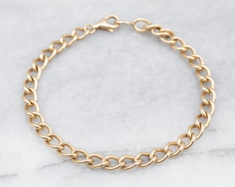May include: A gold chain bracelet with a curb link design.