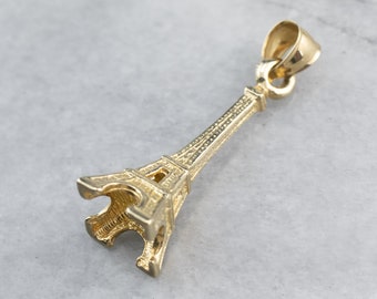 May include: A gold-toned Eiffel Tower charm pendant. The charm is detailed and has a textured surface.