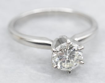Anillo de compromiso solitario de platino con diamante y engaste de seis garras.