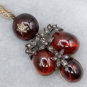 Colgante de la época victoriana de luto con cabujón de granate, diamante talla rosa y rubí.