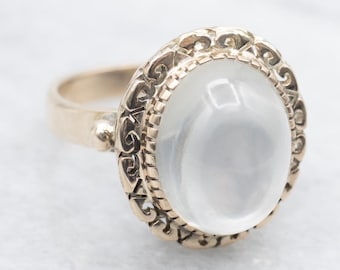 Anello vintage ovale con pietra di luna, con montatura decorata in oro giallo 14 carati.