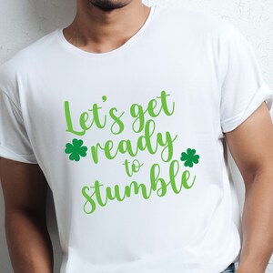May include: White t-shirt with green shamrock graphics and the text "Let's get ready to stumble".
