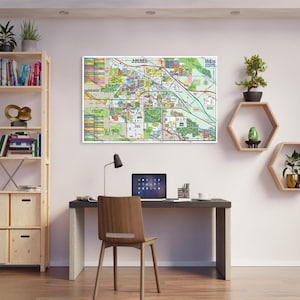May include: A map of Indio, California, hanging on a white wall above a desk with a laptop, a lamp, and a chair. The map is colorful and detailed, showing streets, parks, and other landmarks.