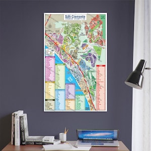 Può includere: Una mappa colorata di San Clemente, California, con una chiave che elenca i quartieri e i punti di interesse. La mappa è stampata su carta bianca e ha un bordo blu.