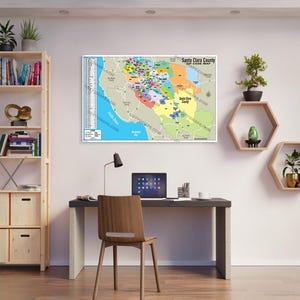 Può includere: Una mappa della contea di Santa Clara, California, che mostra i diversi codici postali. La mappa è stampata su uno sfondo bianco ed è incorniciata da una cornice nera. La mappa è appesa a una parete bianca in un ufficio domestico. C'è una scrivania con una sedia, una lampada e un computer portatile nella stanza.