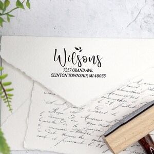 May include: A wooden self-inking return address stamp with the text "Wilsons 7257 Grand Ave. Clinton Township, MI 48035" in black ink.
