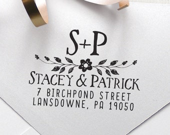 Pode incluir: Um envelope branco com um carimbo de endereço de retorno preto. O carimbo apresenta um desenho floral com as iniciais "S+P" e o texto "Stacey & Patrick, 7 Birchpond Street, Lansdowne, PA 19050".