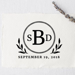 May include: A black and white monogram design featuring the letters "SBD" inside a circular rope border, with decorative leaves and the date "SEPTEMBER 19, 2018" below. A sprig of lavender is placed on the top right.