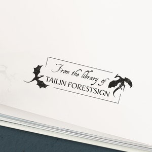 May include: A white page with a black stamp that reads "From the library of Tailin Forestsign" with a dragon design on either side of the text.