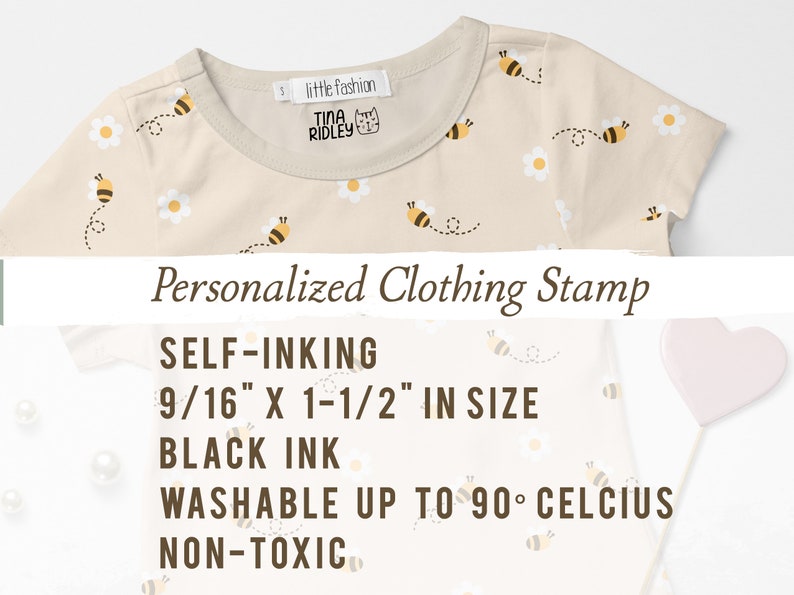 May include: A beige t-shirt with a bee and daisy pattern. The shirt has a label that says "little fashion" and "TINA RIDLEY". The text below the shirt reads "Personalized Clothing Stamp", "SELF-INKING", "9/16" X 1-1/2" IN SIZE", "BLACK INK", "WASHABLE UP TO 90&deg; CELCIUS", and "NON-TOXIC".